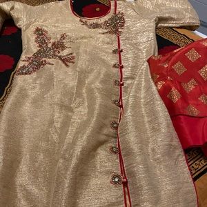 A golden kurta  with a red skart ..